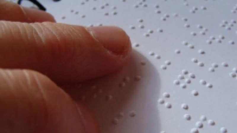 Imagem mostrando os dedos de uma pessoa fazendo a leitura em braille.