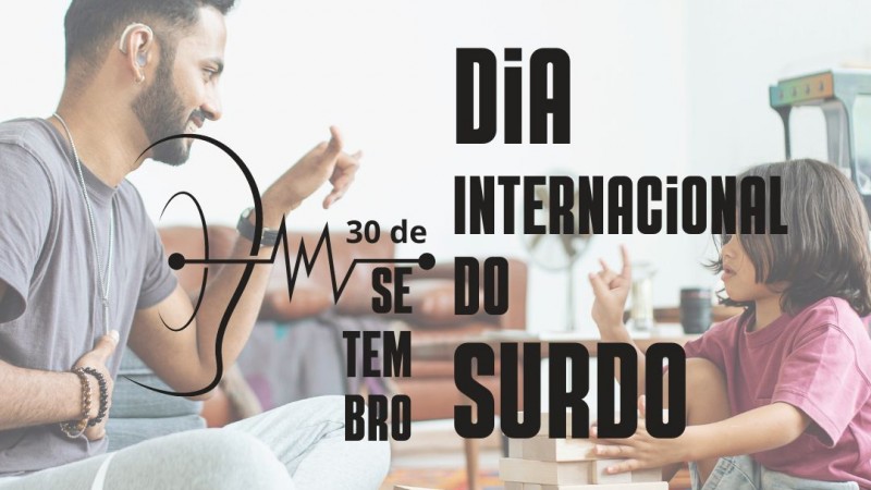 card Dia Internacional do Surdo - no fundo uma foto em transparência com um homem de pele clara e cabelos e barba castanho escuro, vestindo camiseta e calça de abrigo cinza, sentado ao chão e fazendo um sinal em Libras, na sua frente um menino com pele clara, cabelos na altura dos ombros castanho escuro, camiseta em tom de vinho e bermuda jeans, entre os dois um brinquedo de montar, a criança também faz um sinal em Libras...escrito por cima em letras Pretas - 30 DE SETEMBRO - DIA INTERNACIONAL DO SURDO